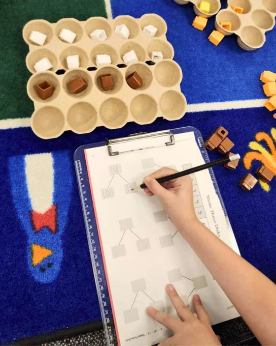 Student working on a Eureka Math² problem while using Unifix cubes.
