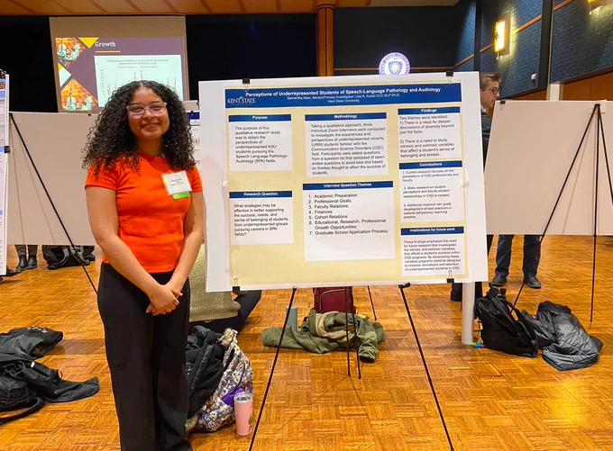 Samantha next to her research poster on perceptions of undergraduate students of speech-language pathology and audiology.
