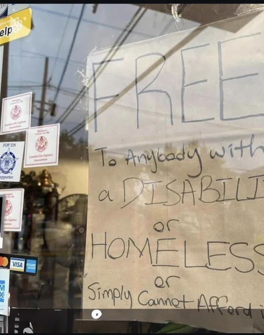 A sign in the restaurant window of a Kebab restaurant reads “To Anybody with a Disability or Homeless or Simply Cannot Afford”