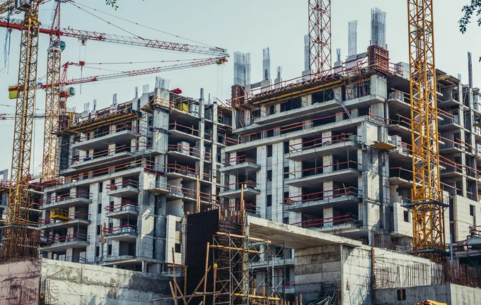 Baustelle mit Kränen im Vordergrund. Foto: Adobe Stock, Fotokon.