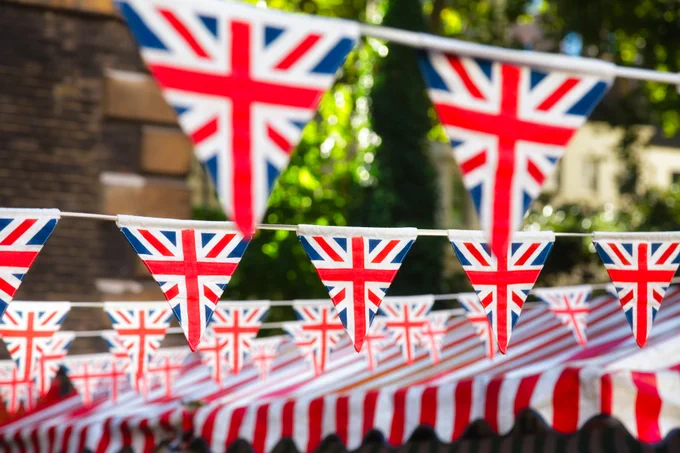 A photo of Union Jack bunting hung up outside on a sunny day.