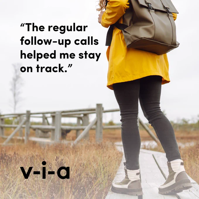 person in yellow raincoat on an outdoor wooden trail with text: "the regular follow-up calls helped me stay on track."