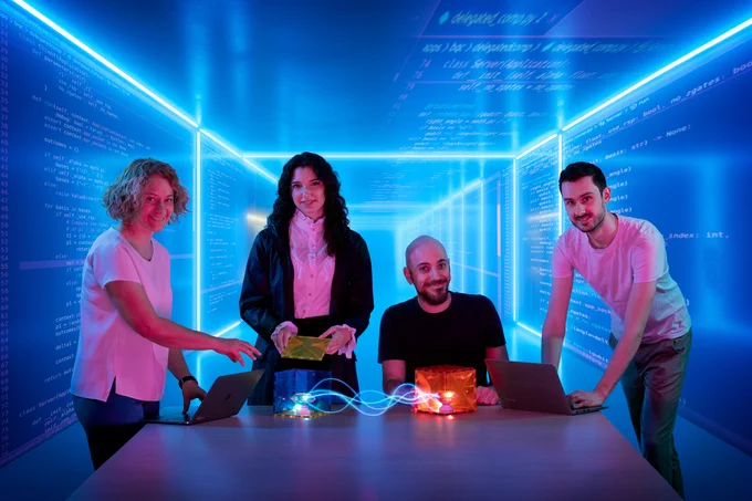 Corresponding author Stephanie Wehner and co-authors Mariagrazia Iuliano, Carlo Delle Donne and Bart van der Vecht against a backdrop of high-level application code that can be run on quantum network hardware through the QNodeOS stack. Photo credit: Studio Oostrum