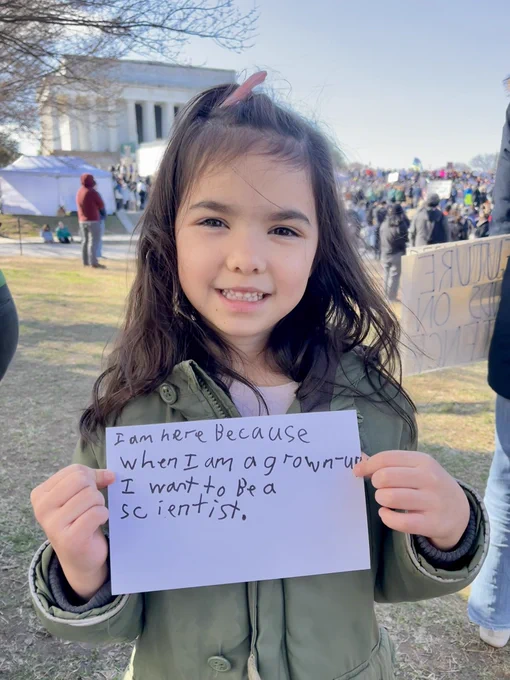 A young girl holding a sign in front of the Lincoln Memorial during the Stand Up For Science rally. The sign says “I am here because when I am a grown-up I want to be a scientist”
