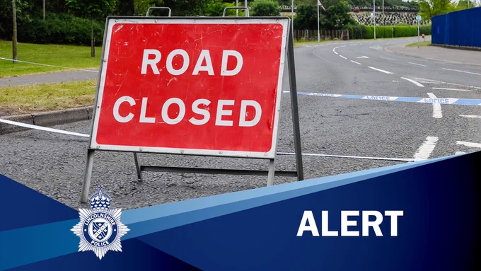 Red 'Road Closed' sign in road with the caption 'ALERT'