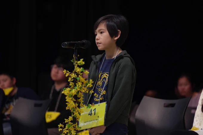 A student stands at the microphone during the Spelling Bee Championships.