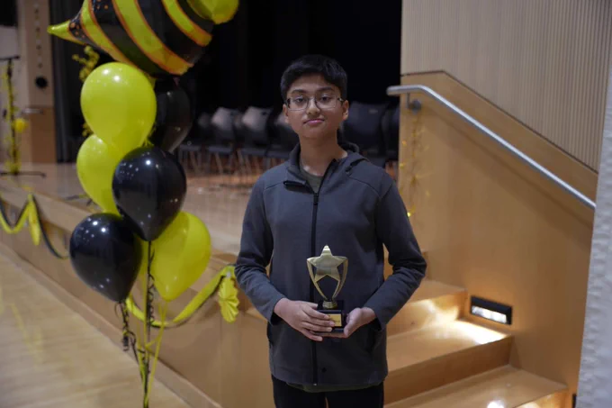 A student holds his trophy after the Spelling Bee Championships. 