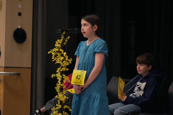 A student stands at the microphone during the Spelling Bee Championships.