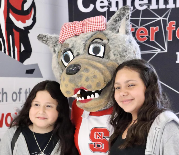 Students pose with Ms. Wuf, a wolf mascot, during a spirit event