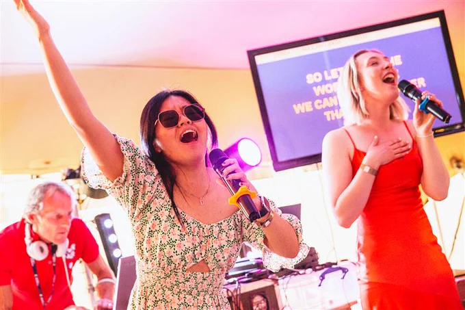 Image of two students singing in the karaoke tent at Grad Ball.