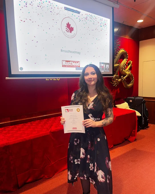 Megan Hederson holding her Gold Feature Article (Academic) award for “Together We Escape,” which tells her story of mental illness and navigating the mental health system.