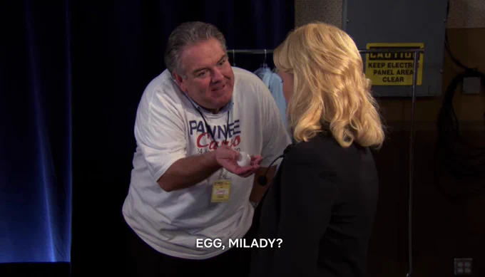 Jerry holding an egg out to Leslie and saying "egg, milady?"