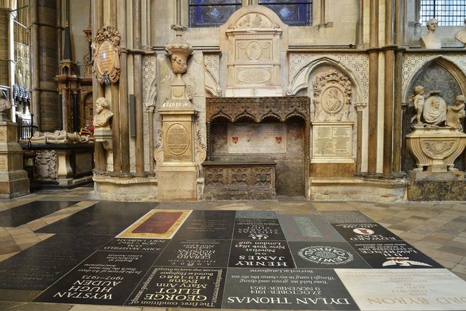 Poets' Corner in Westminster Abbey, with memorial stones to writers in the floor in the foreground, and the tomb of Geoffrey Chaucer on the back wall