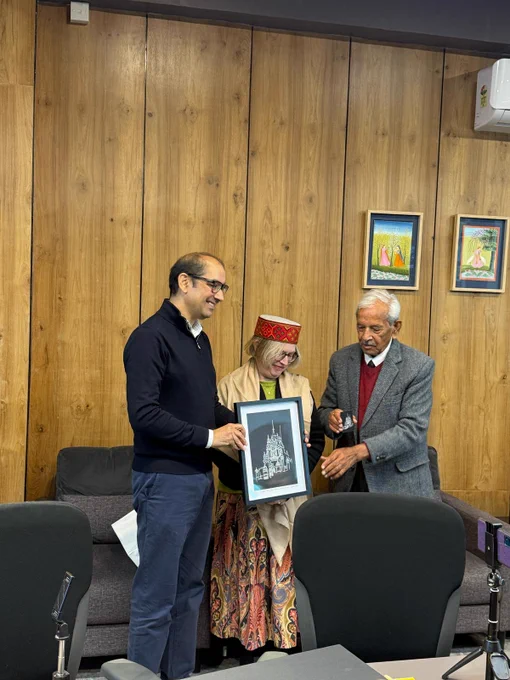 Professor Julie Sanders receives a print from two staff at Shoolini University