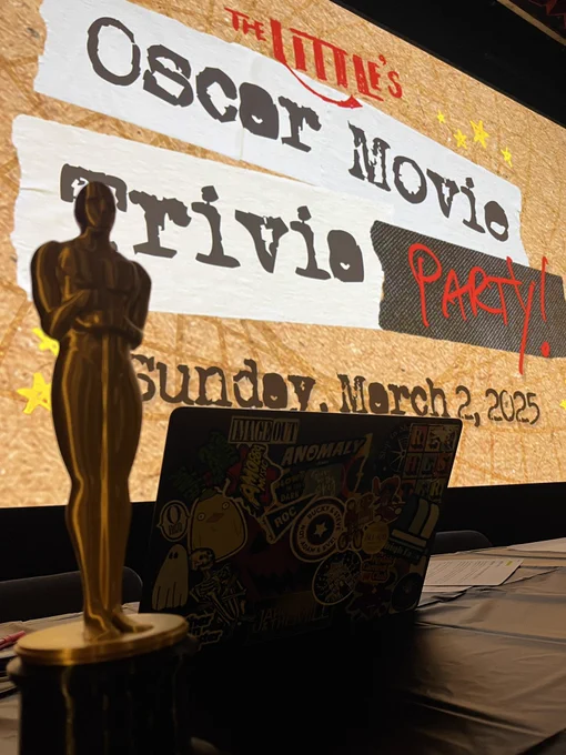 Oscar movie trivia party graphic on screen with a strategically placed statue where the T in trivia is