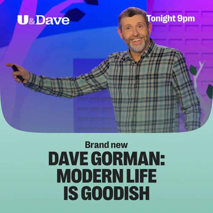 Dave Gorman smiling and pointing to his right, wearing a checked shirt. Text reads: Brand new Dave Gorman: Modern Life is Goodish. Tonight 9pm on U&Dave