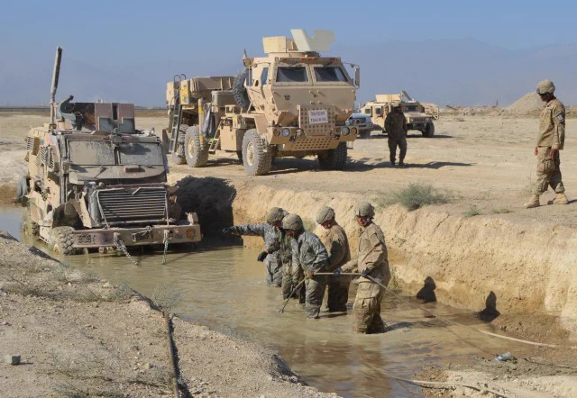 Soldiers recover a vehicle trapped in the muddy water. (Photo Credit: U.S. Army)
