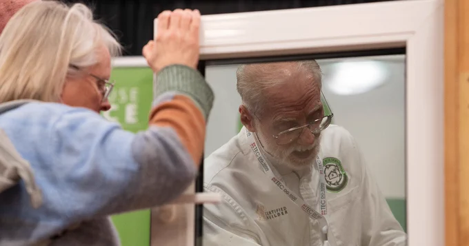 Two individuals are engaged in an animated discussion at a booth.