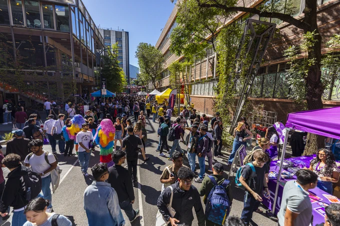A shot down Bowen Street towards Franklin street on a sunny day during O week festivities, there are marquees and lot of students as well as entertainment. 