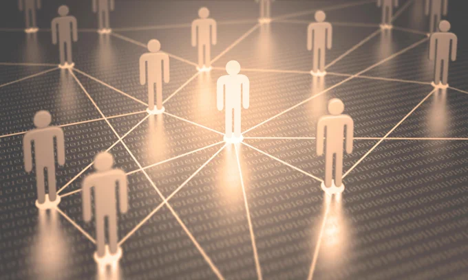 Computer illustration of human figures on dots with interconnected lines over binary code. Some figures, dots, and lines are illuminated in warm white – rest of image is light and dark gray.