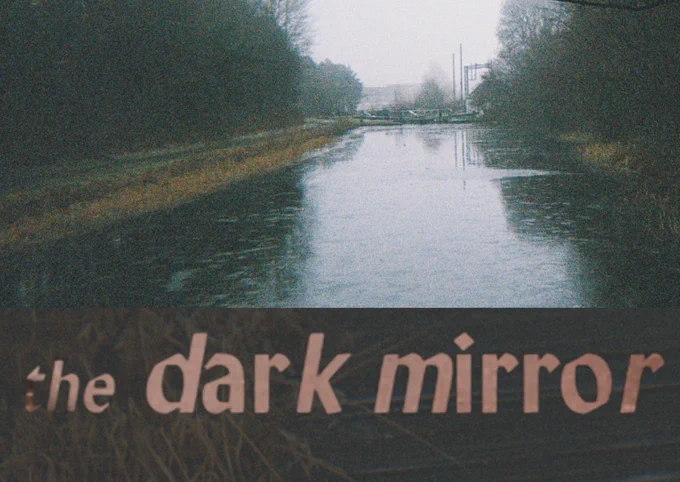 A grainy photograph of a canal above text which reads: 'the dark mirror'.