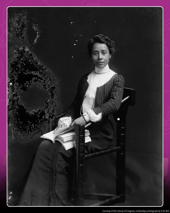 A black-and-white vintage portrait of Anna Julia Cooper seated with a book in hand, dressed in early 20th-century attire.