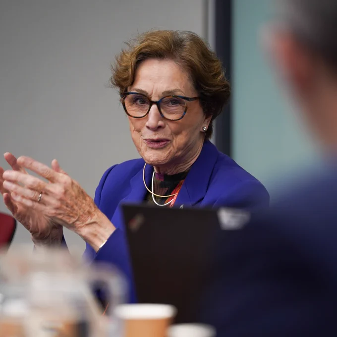 Dame Carol Black in conversation, visibly gesturing with hands.