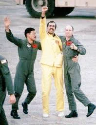 A POW in yellow suit hugs his friends 