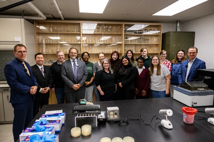 A group poses for a photo in a lab