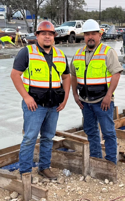two construction superintendent studs in PPE, safety glasses off temporarily for a quick picture