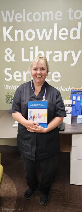 A photo of staff member Lesley Mills holding a copy of the book "a textbook of community nursing"