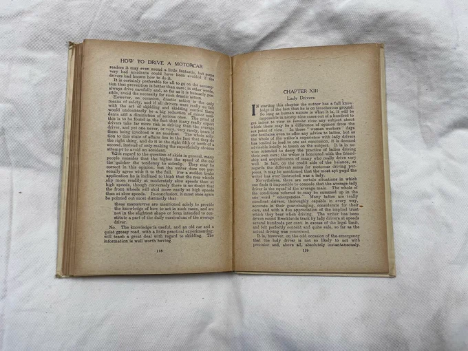 A colour photograph of some pages from the book 'How to Drive a Motorcar'. These pages describe lady drivers.