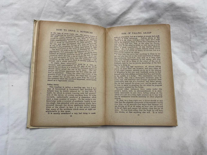 A colour photograph of some pages from the book 'How to Drive a Motorcar'. These pages describe the risks of falling asleep while driving at night.