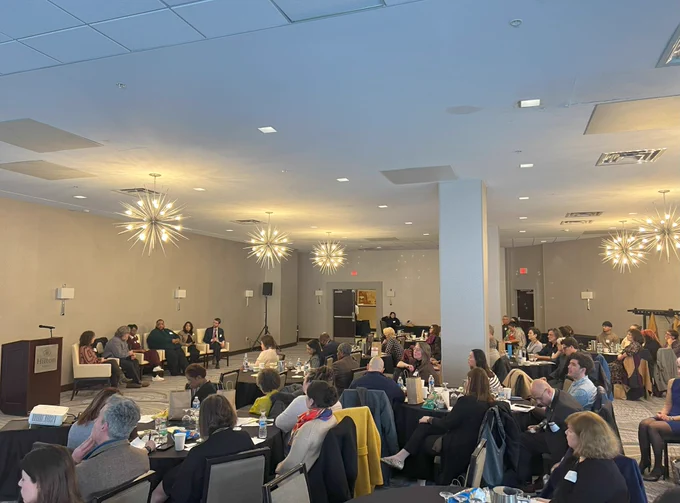 Three photographs of panelists of varying races and genders seated in white chairs inside a room with patterned carpets, beige walls, wall sconces, and large chandeliers. People sit at long and circular tables facing the panel.