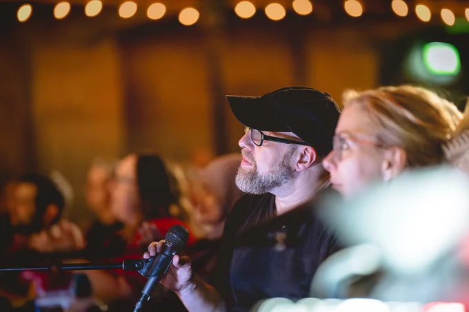 Ali and Adam in directors corner, with the audience in the background.

