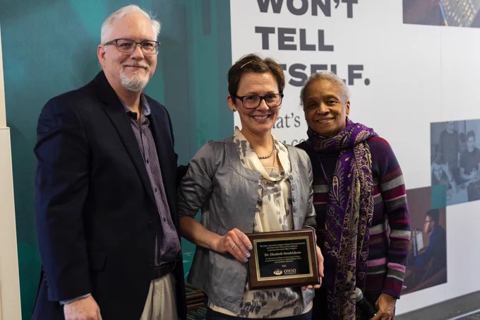 Hendrickson, center, is shown with Dean Scott Titsworth, left, and journalism school director Dr. Eddith Dashiell, right