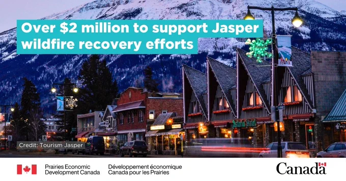 An image of a street in Downtown Jasper at dusk, featuring commercial buildings in the foreground and a large mountain in the background. Text: "Over $2 million to support Jasper wildfire recovery efforts". 