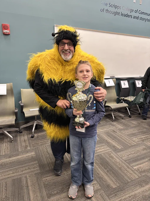Joseph is shown with his trophy assisted by journalism strategic communication Professor Chuck Borghese, aka Super Bee. You can find Chuck buzzing around the Next?! creative agency in Sing Tao Center.