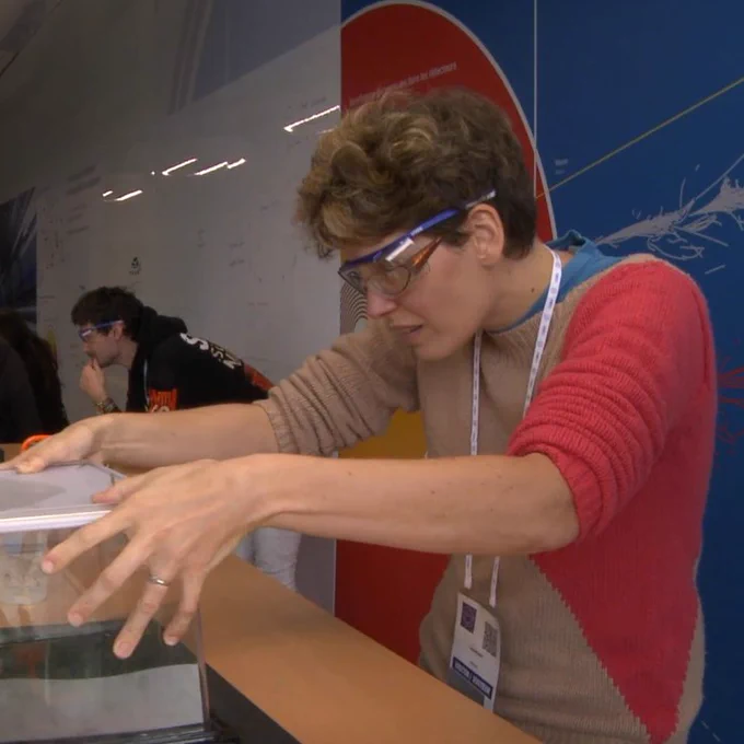 Une enseignante au CERN en train de soulever une boîte (en pleine construction d'une chambre à brouillard)