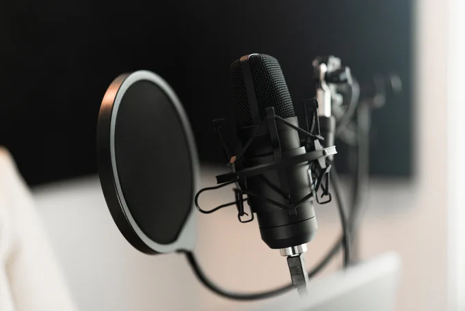 Professional microphone with a pop filter set up in a studio environment, ready for recording.