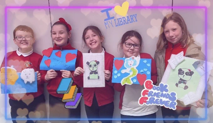 Children from Cowie Library Chatterbooks group holding their Love Libraries themed artwork.