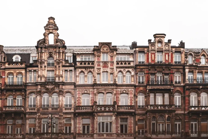 A detailed view of a row of ornate Victorian-style buildings with intricate architectural details and multiple stories.