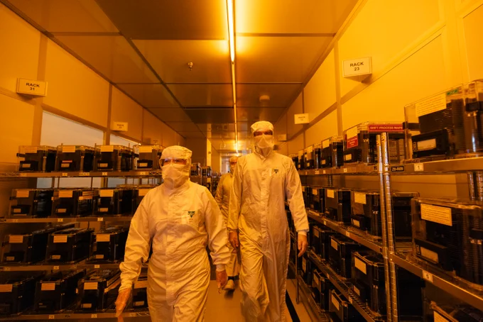 Secretary of State, Peter Kyle, walking down a lab in full PPE along with a technician. 