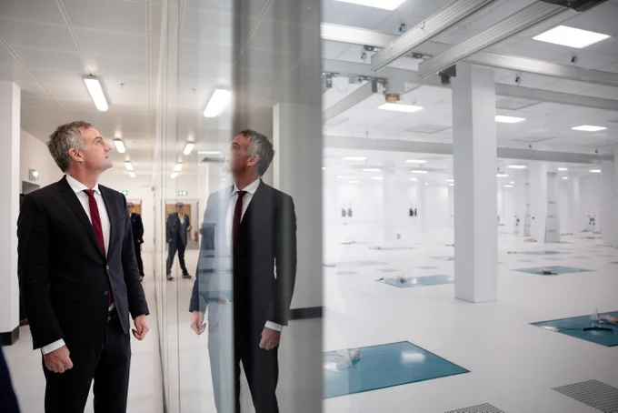 Secretary of State Peter Kyle looking at large reflective surface at Semiconductor factory tour.