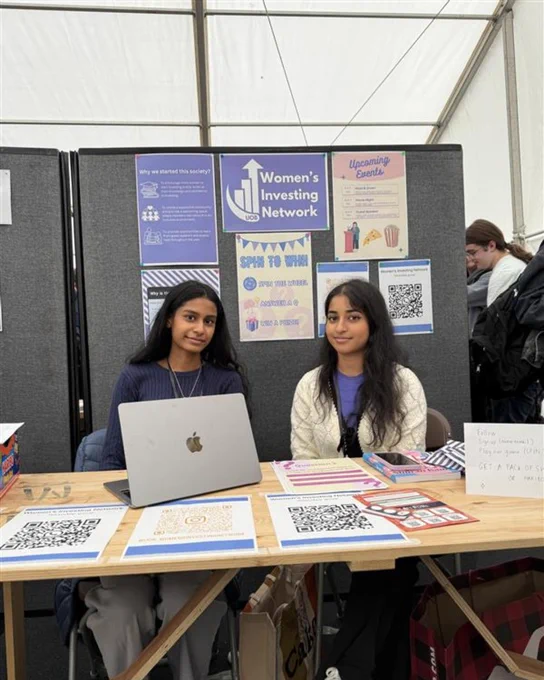 Image of two students smiling at the camera from the 'Women's Investing Network Society'.