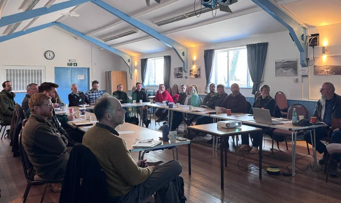 People sitting around tables and discussing items relating to the Large Blue Committee presentation