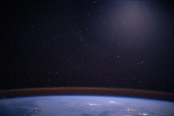 Earth's moonlit horizon glows beneath a starry sky as the International Space Station orbits 263 miles above central Asia. In the foreground, the round curvature of Earth's oceans and clouds captivate in blue and white. In the background the star-speckled distance of space dazzles. Between the darkness of space and the brightness of Earth, a light glow permeates from the atmosphere's horizon. 

Credit: NASA