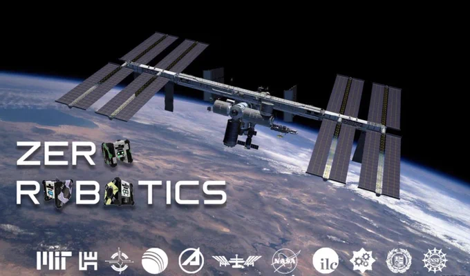 Image of the International Space Station orbiting Earth, with the words Zero Robotics visible in the foreground; the letter "O" has been replaced throughout with images of a tiny robot. The logos of the program sponsors and supporters appear across the bottom of the image. 