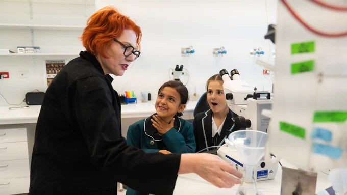 Professor Leonie Quinn shows school students Zara Skepev and Mila Costa the cancer research facilities at the John Curtin School of Medical Research (JCSMR), ANU. Image: Tracey Nearmy/ANU