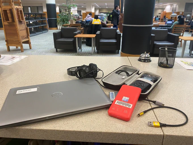 Photo of lap top, phone charger, headphone,  and audio recorder that can be loaned from Mann Library's Help Desk. 